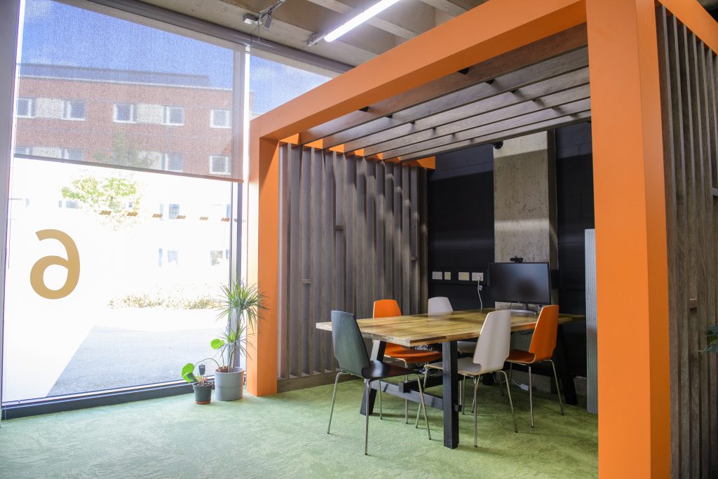 Another of the break out spaces in our studio - a slatted pod with a team table and 5 chairs, next to a bright window